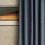 Rideau bleu élégant en arrière-plan, intégré dans un intérieur moderne avec un tableau encadré. Idéal pour ajouter une touche contemporaine et sophistiquée à votre salon ou chambre. Parfait pour créer une ambiance cosy tout en assurant une décoration épurée.