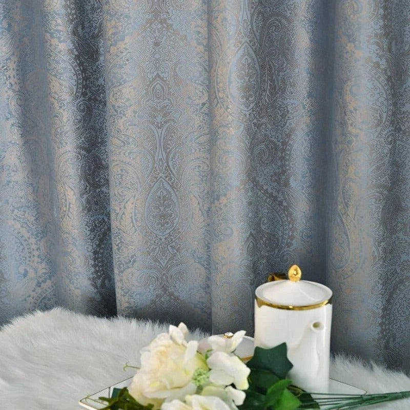 Rideau élégant avec motif damassé, idéal pour la décoration intérieure sophistiquée. Ce rideau ajoute une touche d'élégance et de raffinement à n'importe quel salon ou chambre. Son design intemporel met en valeur l'esthétique de votre espace, complété par des accessoires décoratifs comme un vase et des fleurs blanches pour une ambiance charmante et apaisante.