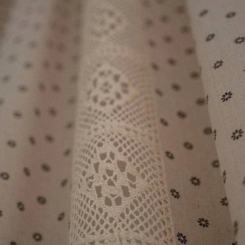 Motifs délicats de dentelle et petites fleurs sur fond beige, parfaits pour une décoration intérieure élégante. Ce tissu aux motifs raffinés apporte une touche de charme vintage à votre espace de vie. Idéal pour rideaux, nappes ou projets créatifs, il se distingue par son design subtil et son allure chic.
