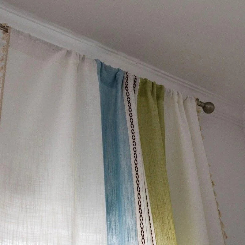 Rideaux multicolores élégants avec motifs décoratifs sur tringle en métal, idéaux pour ajouter une touche de style moderne à votre intérieur. Découvrez comment ces rideaux combinent des teintes de blanc, bleu et vert pour sublimer la décoration de votre salon ou chambre. Faciles à installer, parfaits pour personnaliser et illuminer votre espace de vie.