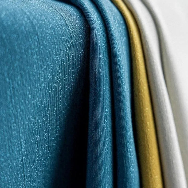 Tissus colorés texturés en nuances de bleu, jaune et blanc, parfaits pour la confection de rideaux ou la décoration intérieure moderne.