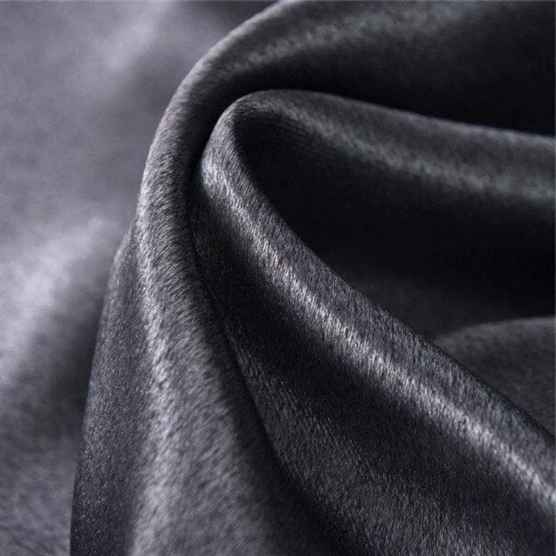 Tissu noir élégant avec texture brillante et ondulée, idéal pour la confection de vêtements haute couture, décoration intérieure luxueuse et accessoires de mode sophistiqués.