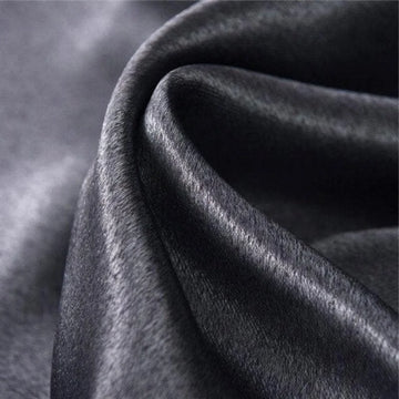 Tissu noir élégant avec texture brillante et ondulée, idéal pour la confection de vêtements haute couture, décoration intérieure luxueuse et accessoires de mode sophistiqués.