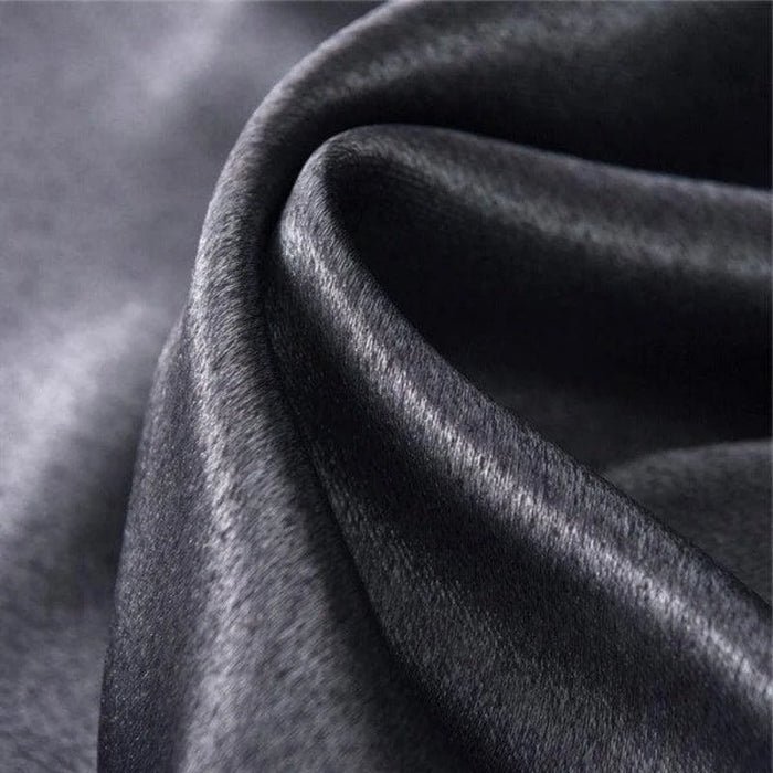 Tissu noir élégant avec texture brillante et ondulée, idéal pour la confection de vêtements haute couture, décoration intérieure luxueuse et accessoires de mode sophistiqués.