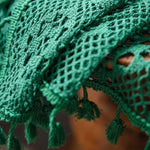 Texture d'un tissu vert avec motifs en dentelle et franges, parfait pour ajouter une touche d'élégance à votre décoration intérieure. Idéal pour les amateurs de design d'intérieur à la recherche de détails uniques et raffinés. Ajoutez du style et du charme à votre espace de vie avec cet accessoire décoratif distinctif.