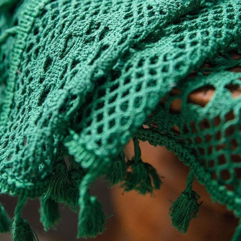 Texture d'un tissu vert avec motifs en dentelle et franges, parfait pour ajouter une touche d'élégance à votre décoration intérieure. Idéal pour les amateurs de design d'intérieur à la recherche de détails uniques et raffinés. Ajoutez du style et du charme à votre espace de vie avec cet accessoire décoratif distinctif.