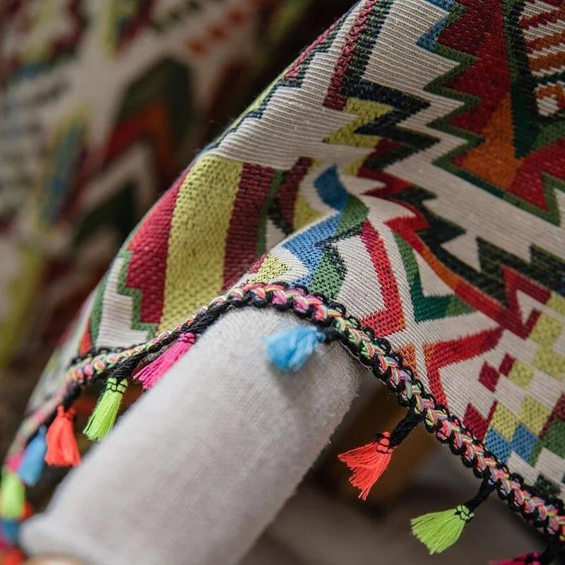 Plaid coloré avec motifs géométriques et petites franges élégantes, parfait pour ajouter une touche vibrante et stylée à votre salon ou chambre à coucher. Accessoire de décoration tendance qui dynamise votre intérieur grâce à son design unique et ses couleurs vives.