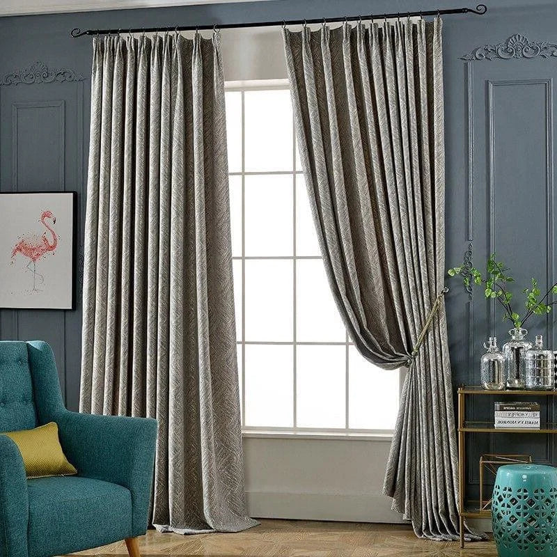Rideaux élégants pour salon, couleur grise, offrant un style moderne et élégant. Idéaux pour rehausser la décoration intérieure, ces rideaux assurent une ambiance chaleureuse et accueillante. Leur design raffiné s'accorde parfaitement avec des meubles contemporains, comme un fauteuil bleu. Accessoire indispensable pour contrôler la lumière et créer un espace cosy.