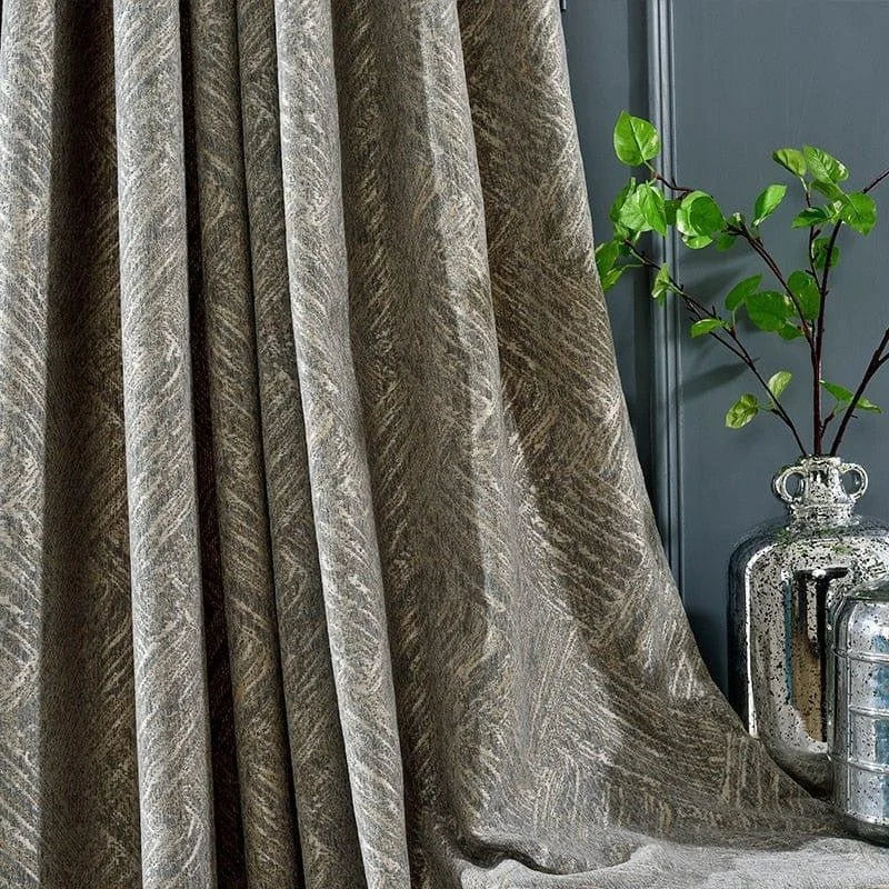 Rideau élégant aux motifs texturés, accroché dans un intérieur contemporain. Décor idéal pour ajouter une touche sophistiquée à une pièce. Accompagné d'une plante verte et de vases décoratifs sur fond de mur gris. Ambiance chic et moderne pour le salon ou la chambre.