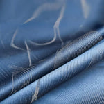 Image en gros plan d'un tissu bleu avec motif élégant, parfait pour la décoration intérieure ou la confection vestimentaire. Convient idéalement pour un usage professionnel ou domestique, ajoutant une touche de sophistication à tout espace.