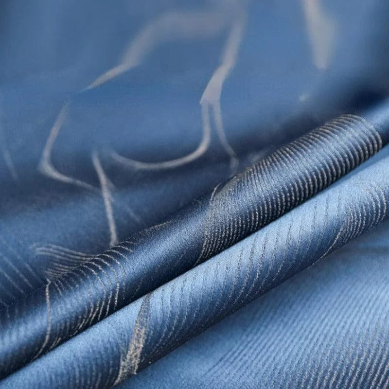 Image en gros plan d'un tissu bleu avec motif élégant, parfait pour la décoration intérieure ou la confection vestimentaire. Convient idéalement pour un usage professionnel ou domestique, ajoutant une touche de sophistication à tout espace.