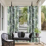 Balancelle extérieure élégante sur une terrasse, idéale pour un moment de détente en plein air. Cette balancelle suspendue est entourée de rideaux à motifs tropicaux, créant un espace cosy et intime. Le mobilier de jardin est complété par une table d'appoint moderne et des coussins confortables, parfaits pour l'été. Cette installation s'intègre harmonieusement dans un environnement verdoyant, offrant une ambiance relaxante et naturelle.