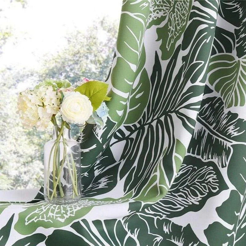 Rideau à motif tropical vert avec feuillage, idéal pour créer une ambiance nature dans votre intérieur. Décorez votre salon ou chambre avec ce joli design végétal. Le contraste entre le motif et les tons de vert apporte fraîcheur et élégance à votre espace. Parfait pour les amateurs de décoration intérieure inspirée par la nature.