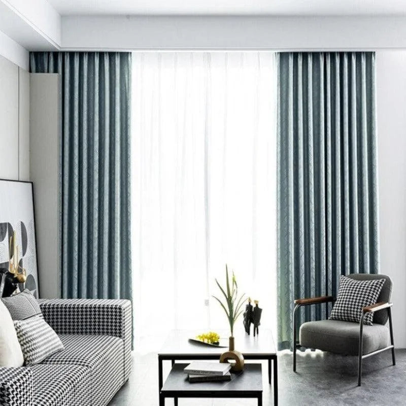 Rideaux modernes bleu foncé dans un salon élégant, illuminant la pièce avec une lumière diffuse. Canapé et fauteuil contemporains avec motifs géométriques, table basse design avec décoration minimaliste. Parfait pour une décoration d'intérieur raffinée et moderne. Idéal pour créer une ambiance chaleureuse et accueillante dans un espace de vie.