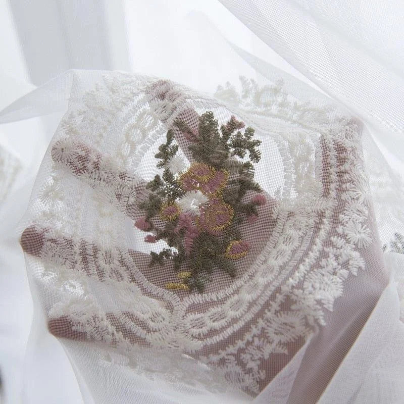 Détail délicat de dentelle brodée avec motif floral aux couleurs naturelles, parfait pour des créations élégantes et sophistiquées.