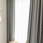 Rideaux modernes de salon gris, créant une ambiance élégante et accueillante, idéaux pour réguler la lumière naturelle dans votre intérieur. Accessoire décoratif essentiel pour une décoration contemporaine.