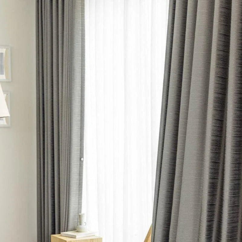 Rideaux modernes de salon gris, créant une ambiance élégante et accueillante, idéaux pour réguler la lumière naturelle dans votre intérieur. Accessoire décoratif essentiel pour une décoration contemporaine.