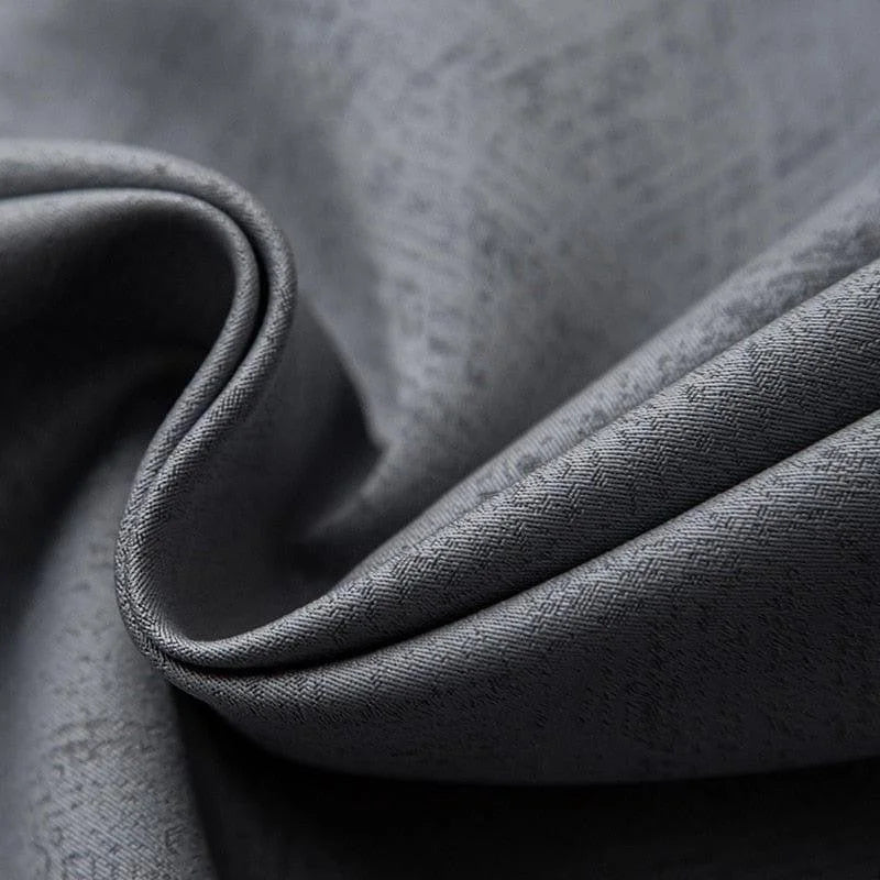 Gros plan sur un tissu gris élégant avec une texture en motif subtil, idéal pour la confection de vêtements sophistiqués ou la décoration moderne d'intérieur. Ce textile raffiné apporte une touche chic à tout projet de couture ou d'aménagement.