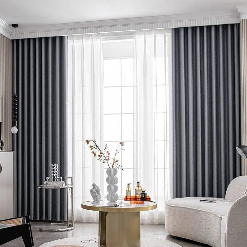 Rideaux élégants gris obscur décorant un salon moderne, créant une ambiance cosy et sophistiquée, idéal pour optimiser la lumière naturelle tout en préservant l'intimité. Parfait pour une décoration intérieure contemporaine.