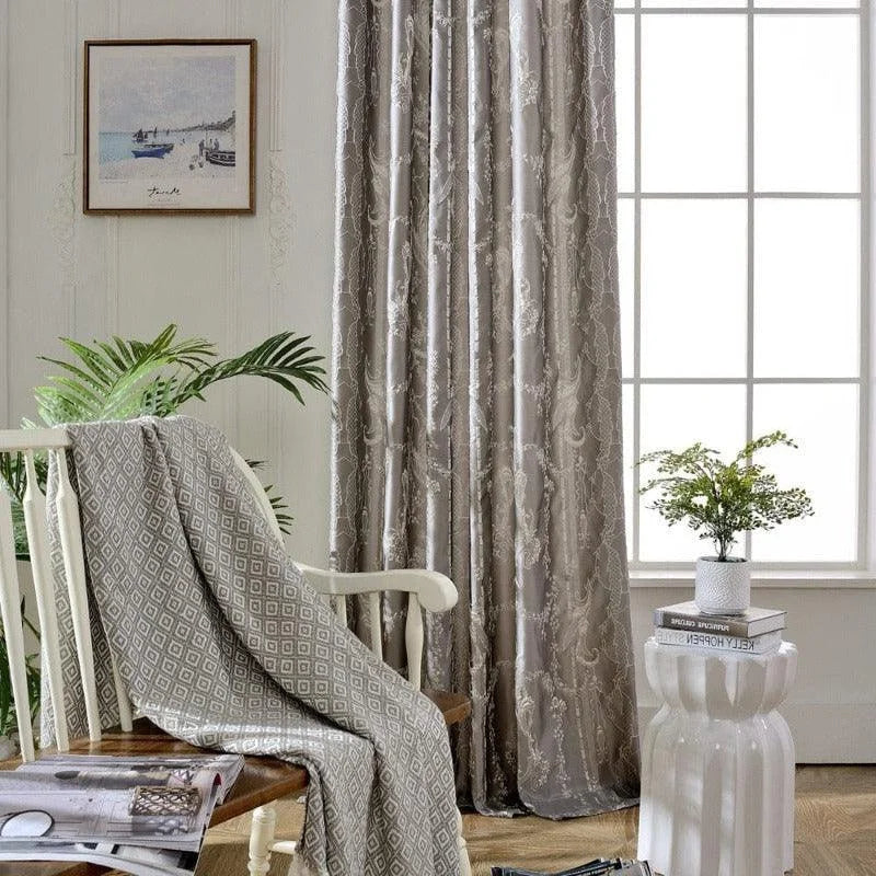 Rideaux élégants gris clair avec motifs subtils pour salon moderne, ambiance lumineuse et accueillante. Décoration intérieure avec plante verte, tableau mural et éléments de design contemporain.