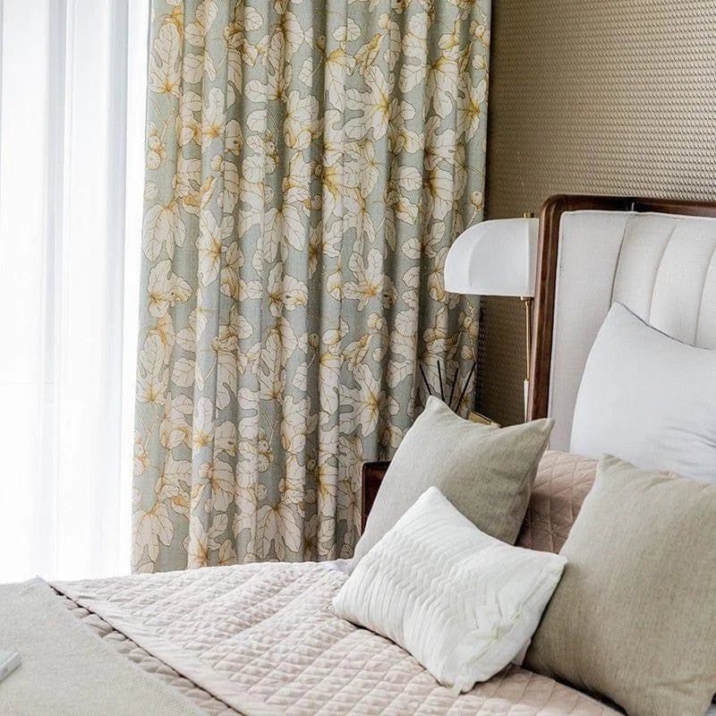 Chambre élégante avec rideaux à motifs floraux, lit confortable et coussins décoratifs, ambiance lumineuse et apaisante. Parfait pour une décoration intérieure moderne et raffinée.