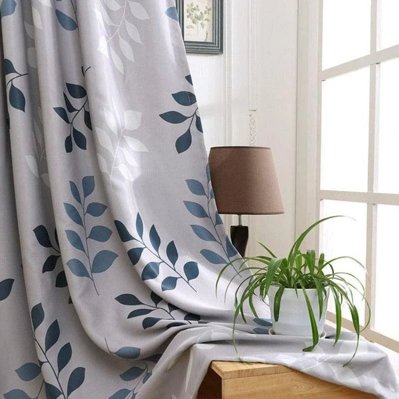 Rideau décoratif élégant à motifs de feuilles bleues, idéal pour apporter une touche de nature et de modernité à votre salon. Parfait pour créer une ambiance apaisante et lumineuse grâce à sa capacité à filtrer délicatement la lumière. Accessoire tendance pour sublimer vos fenêtres.
