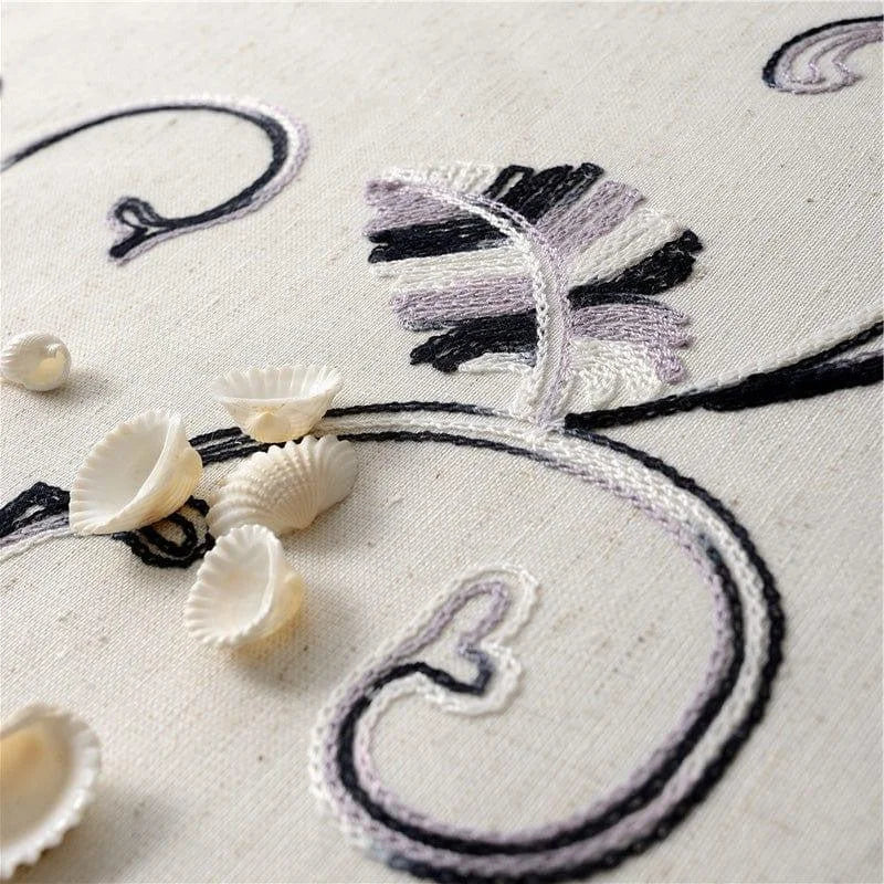 Détail artistique d'un design floral brodé sur un tissu clair, accompagné de coquillages délicats. Cette image met en avant l'élégance et le style d'un motif décoratif sophistiqué, idéal pour la décoration intérieure. Le contraste des couleurs entre les motifs et le fond ajoute une touche de raffinée, parfaite pour embellir n'importe quel espace de vie.
