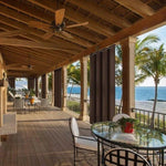 Terrasse spacieuse avec vue sur la mer idéale pour des moments de détente en plein air. Ventilateurs de plafond pour un confort optimal, et rideaux élégants pour l’intimité. Mobilier de jardin moderne qui complète parfaitement cet espace extérieur. Découvrez une expérience de vie côtière inégalée avec une ambiance tropicale et relaxante.
