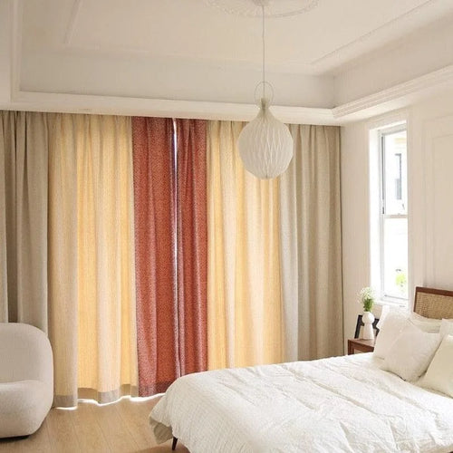 Chambre moderne élégante avec lit double et rideaux colorés créant une ambiance chaleureuse. Luminaire design suspendu pour un éclairage doux. Fenêtre apportant une lumière naturelle à la pièce. Décoration minimaliste pour un espace de repos apaisant.