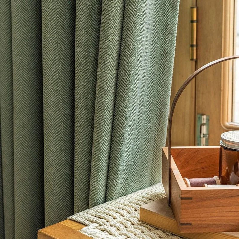 Rideau vert élégant avec motif chevrons, idéal pour une décoration intérieure moderne. Parfait pour ajouter une touche de sophistication à votre salon ou chambre. Complémente harmonieusement des accessoires en bois, révélant une ambiance chaleureuse et naturelle.