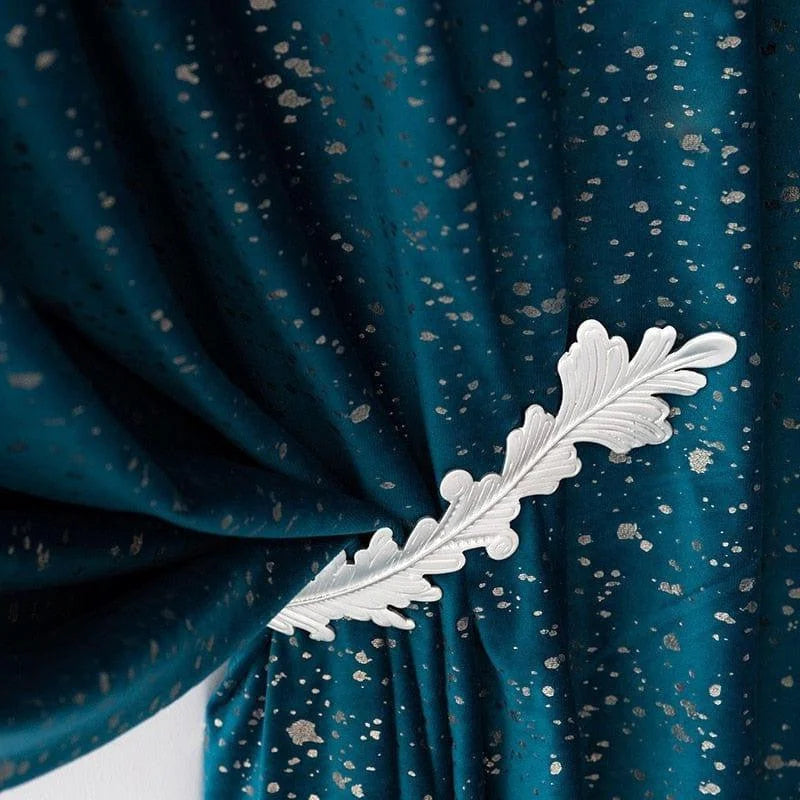 Rideau élégant bleu avec motifs argentés, orné d'un embrasse décorative en forme de feuille, idéal pour ajouter une touche de sophistication et de style à votre intérieur moderne ou classique.