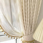 Rideau beige élégant avec embrasse sophistiquée, idéal pour sublimer votre intérieur. Décoration raffinée pour fenêtres avec finitions dorées et pompons décoratifs. Ajoute une touche chic à votre salon ou chambre, permettant un jeu de lumière subtil. Accessoire décoratif parfait pour un style classique et intemporel.