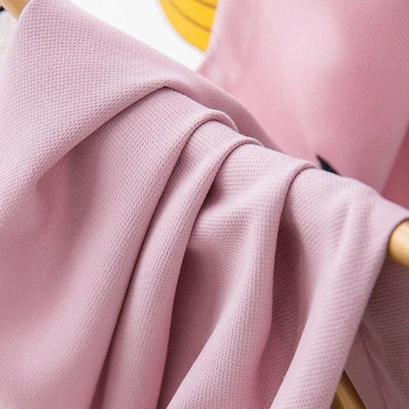 Étoffe rose élégante suspendue à un support, idéale pour confectionner des vêtements modernes et raffinés. Tissu fluide et doux, parfait pour apporter une touche de sophistication à votre garde-robe. Belle texture et couleur délicate, un choix parfait pour des créations tendance.