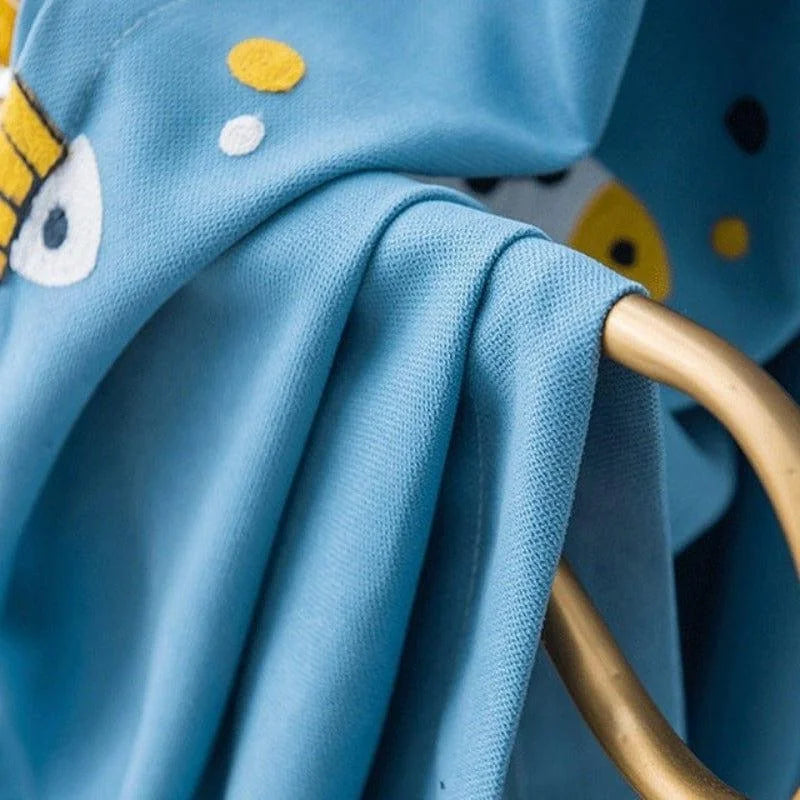 Délai de livraison produit : Image d'un tissu bleu à motifs colorés suspendu à une tringle dorée, parfait pour une décoration intérieure moderne. Ajoutez une touche chic et contemporaine avec ce design unique et élégant.