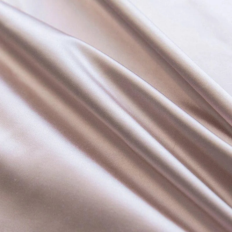 Texture fluide et soyeuse d'un tissu luxueux rose pâle, idéal pour la confection de vêtements élégants et raffinés, offrant un drapé élégant et une brillance subtile qui rehaussera toute création.