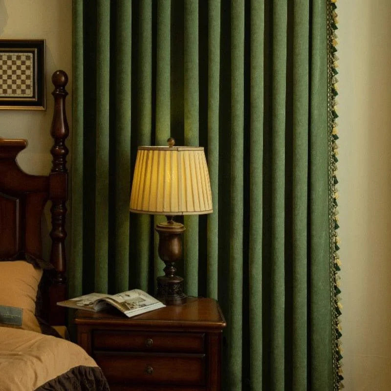 Rideau vert élégant dans une chambre classique, accompagné d'une lampe de chevet sur une table en bois. Le rideau ajoute une touche de sophistication à la décoration intérieure. Luminosité douce de la lampe pour une ambiance chaleureuse. Décoration de chambre avec des rideaux et meubles en bois pour un style traditionnel et chic.