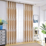 Rideaux élégants avec motifs décoratifs placés dans un salon lumineux. Décoration intérieure raffinée comprenant des rideaux beiges aux motifs blancs, accentuant une ambiance moderne et chaleureuse. Accessoires tendance complétant le design, tels qu'un meuble de rangement et des plantes d'intérieur, créant un espace accueillant et harmonieux. Fenêtre baignée de lumière naturelle, idéale pour les pièces à vivre contemporaines.