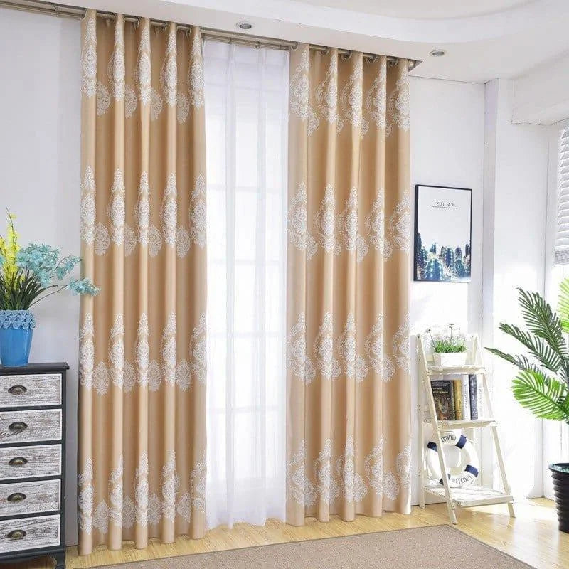 Rideaux élégants avec motifs décoratifs placés dans un salon lumineux. Décoration intérieure raffinée comprenant des rideaux beiges aux motifs blancs, accentuant une ambiance moderne et chaleureuse. Accessoires tendance complétant le design, tels qu'un meuble de rangement et des plantes d'intérieur, créant un espace accueillant et harmonieux. Fenêtre baignée de lumière naturelle, idéale pour les pièces à vivre contemporaines.