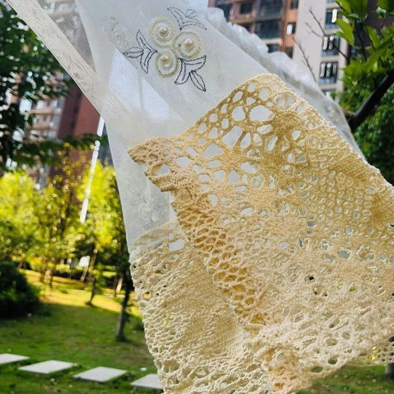 Écharpe élégante en dentelle beige avec motifs floraux, suspendue dans un jardin verdoyant, idéale pour les tenues estivales. Cette pièce unique ajoute une touche de sophistication et de raffinement à votre style, parfaite pour les occasions spéciales ou un usage quotidien. Découvrez comment cet accessoire polyvalent peut rehausser votre garde-robe avec charme et élégance.