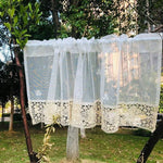 Petit rideau décoratif blanc suspendu en extérieur, idéal pour apporter une touche élégante et raffinée à une fenêtre. Design orné de motifs brodés et bordure en crochet, parfait pour une décoration intérieure charmante. Adapté aux espaces modernes comme classiques, ce rideau combine esthétique et fonctionnalité.