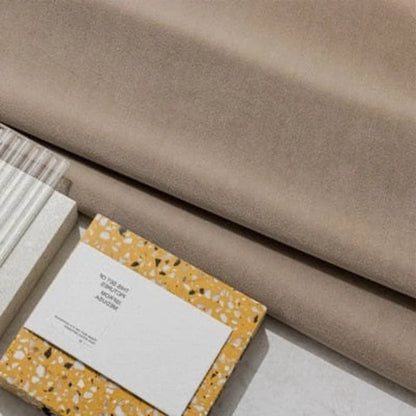 Image montrant des échantillons de design, avec un tissu beige en arrière-plan et des carnets de notes colorés plats. Parfait pour l'inspiration en décoration intérieure ou le choix de palettes de couleurs pour l'aménagement d'espace. Style moderne et élégant, idéal pour des projets créatifs ou tendances.