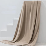 Couverture beige élégante drapée sur des escaliers blancs, ajoutant une touche de sophistication et de confort à votre intérieur. Idéale pour le salon ou la chambre, cette couverture offre chaleur et style. Parfait pour décorer tout en apportant une sensation douce et agréable au toucher.