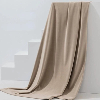 Couverture beige élégante drapée sur des escaliers blancs, ajoutant une touche de sophistication et de confort à votre intérieur. Idéale pour le salon ou la chambre, cette couverture offre chaleur et style. Parfait pour décorer tout en apportant une sensation douce et agréable au toucher.
