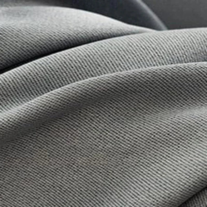 Plan serré sur un tissu gris avec un tissage serré, idéal pour la décoration intérieure et les projets de couture. Découvrez la texture élégante et les nuances subtiles de ce matériau d'ameublement polyvalent.