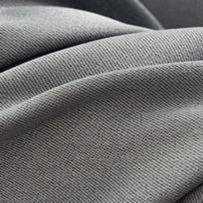 Plan serré sur un tissu gris avec un tissage serré, idéal pour la décoration intérieure et les projets de couture. Découvrez la texture élégante et les nuances subtiles de ce matériau d'ameublement polyvalent.