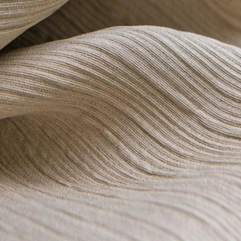 Texture plissée élégante beige, idéale pour la décoration intérieure ou la confection de vêtements chics. Cette surface ondulée ajoute une touche sophistiquée à tout design textile.