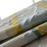 Image d'un tissu délicatement plié, présentant un motif élégant avec des couleurs douces et harmonieuses, parfait pour sublimer la décoration intérieure de votre maison. Ce textile tendance est idéal pour ajouter une touche de sophistication et de modernité à vos espaces.