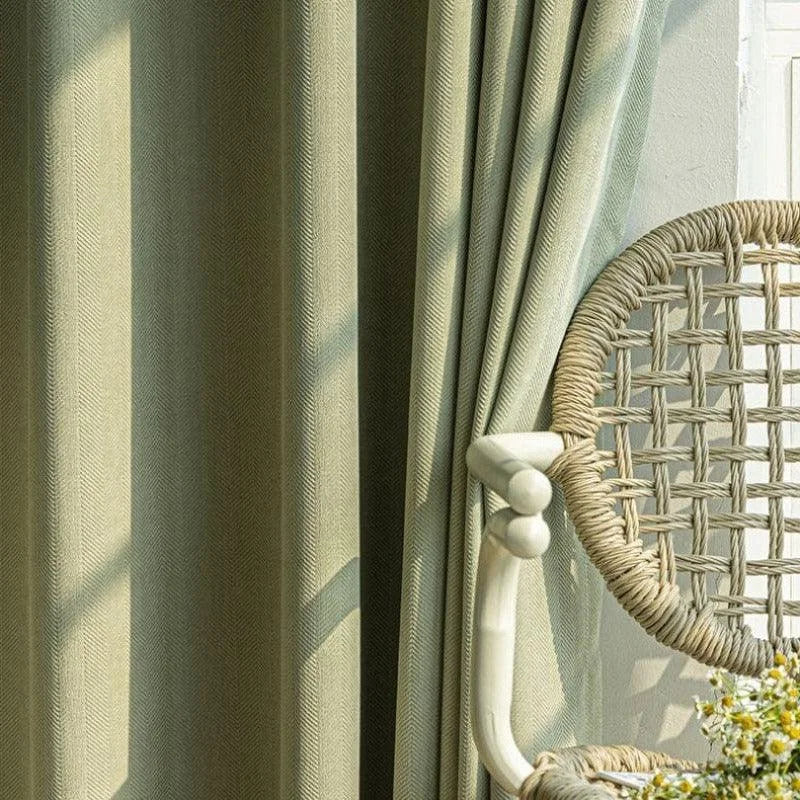Rideaux élégants couleur vert olive avec chaise tressée, parfaits pour une décoration intérieure naturelle et lumineuse. Idéal pour apporter une touche de confort et de style à votre salon ou chambre. L'ensemble crée une atmosphère apaisante et accueillante.