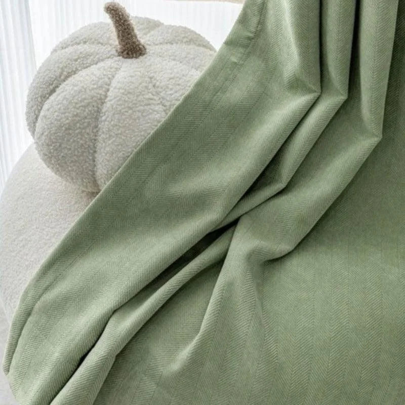 Plaid vert décoratif drapé sur un fauteuil, accompagné d'un coussin original en forme de citrouille. Ce plaid ajoute une touche de confort et d'élégance à votre intérieur, idéal pour réchauffer vos soirées tout en apportant une note de couleur apaisante. Accessoire de maison indispensable pour créer une ambiance cosy et accueillante.