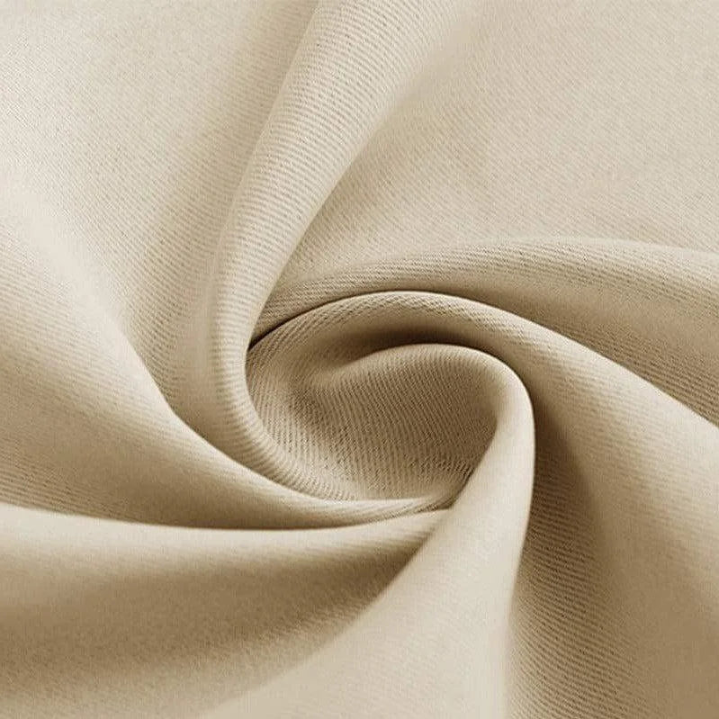 Texture drapée beige d'un tissu, capture rapprochée présentant des plis élégants et une apparence soyeuse, idéale pour décoration d'intérieur et ameublement moderne.